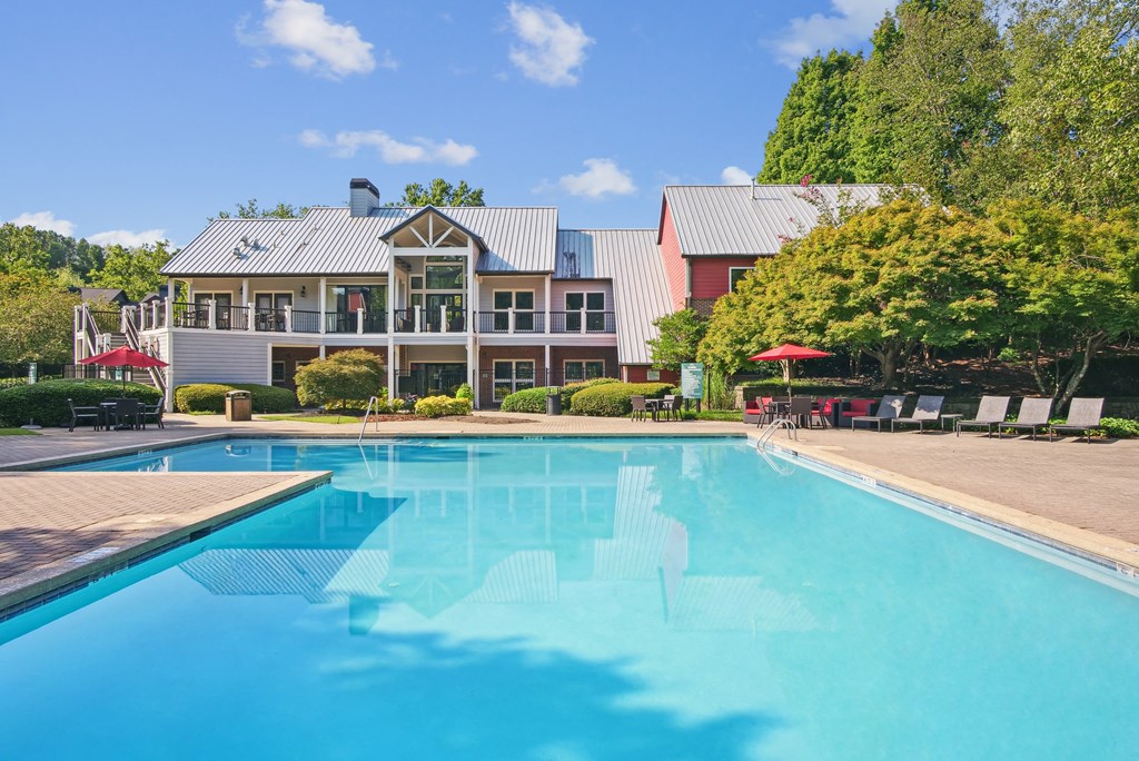 A large swimming pool in front of a building with a red roof at Elme Druid Hills, Atlanta, Georgia